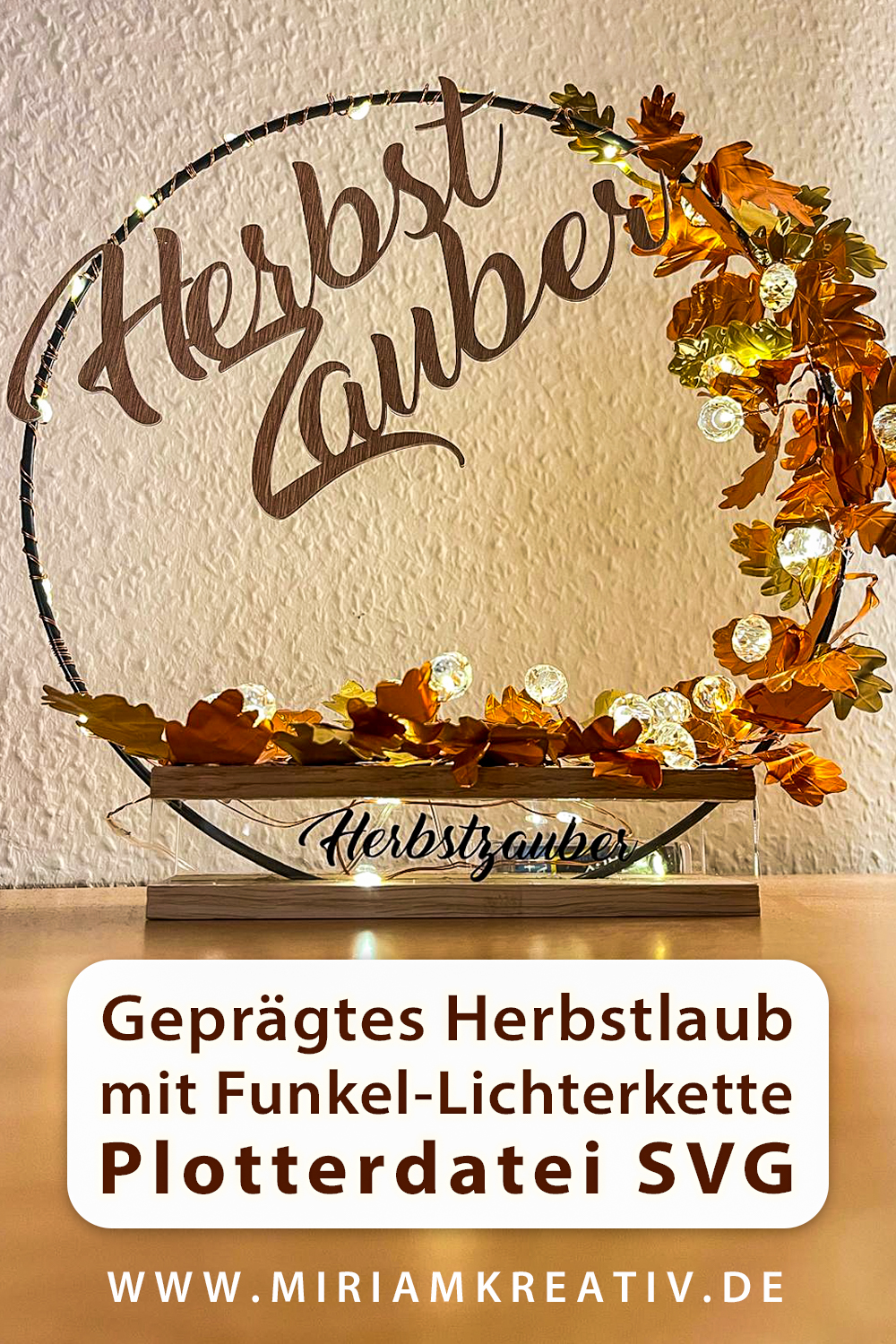 Herbstlicher Blätterkranz aus Alu-Prägefolie, gestaltet mit der Plotterdatei Deko-Blätterkranz Eiche, in warmen Farben leuchtend durch die Lichterkette, Kundenfoto von Birgit Grundhoff
